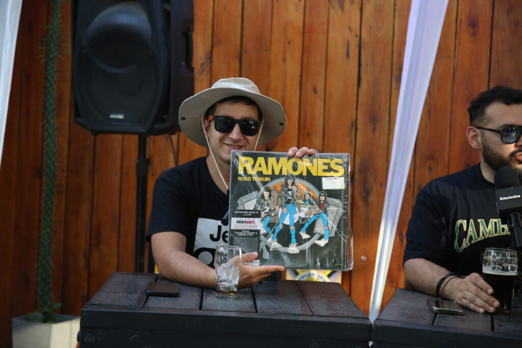 Integrante del staff muestra “Road to Ruin” de Ramones durante el streaming por los 100K en Peñón del Águila, Funes.