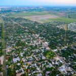 Clima en Funes: vista aérea de la ciudad al atardecer con la zona urbana y el campo al fondo