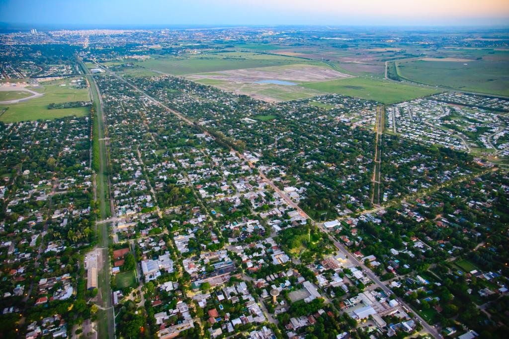 Clima en Funes: vista aérea de la ciudad al atardecer con la zona urbana y el campo al fondo