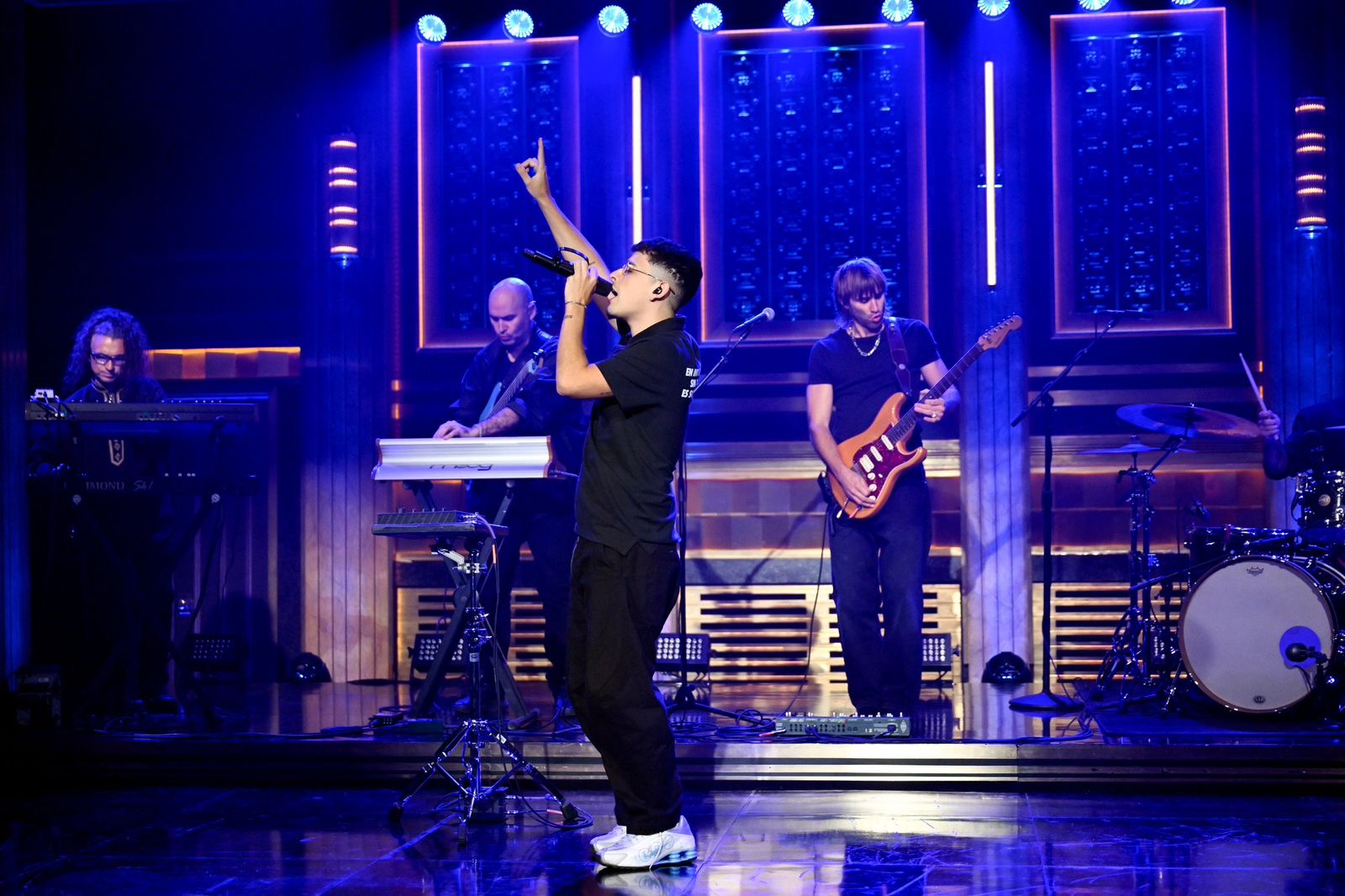 Trueno en Jimmy Fallon levantando el brazo con la banda en el escenario