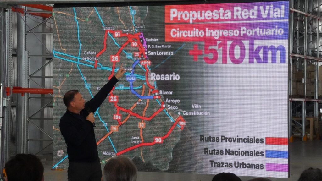 El ministro Lisandro Enrico señala el mapa del Circuito de Ingreso Portuario durante la apertura de sobres del Camino de la Cremería