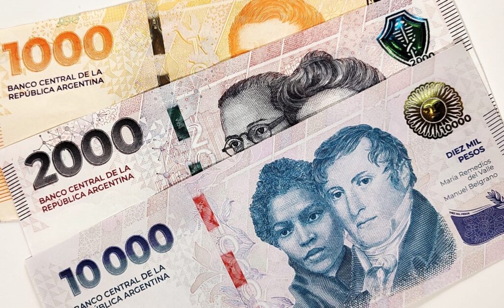 Canasta básica abril 2026: billetes de pesos argentinos sobre una mesa