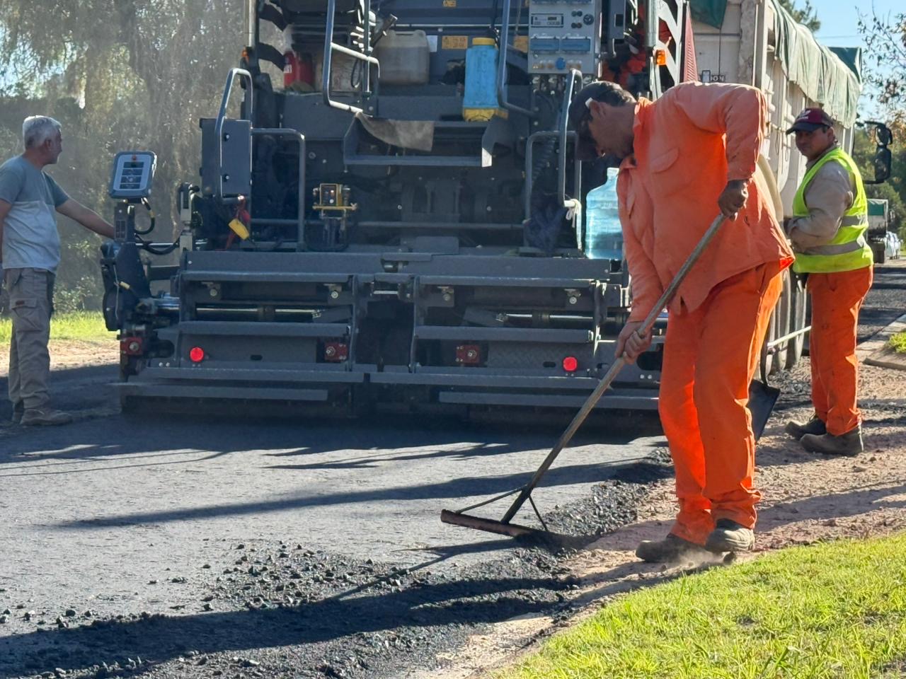 Operario municipal trabaja en la pavimentación en Roldán con asfalto fresco