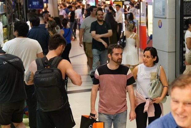 Shoppings descuentos: gente caminando con bolsas en un centro comercial