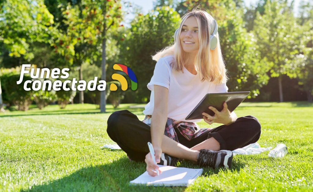 Funes conectada: una joven navega con su tablet y el Wi-Fi gratuito de Funescoop en una plaza