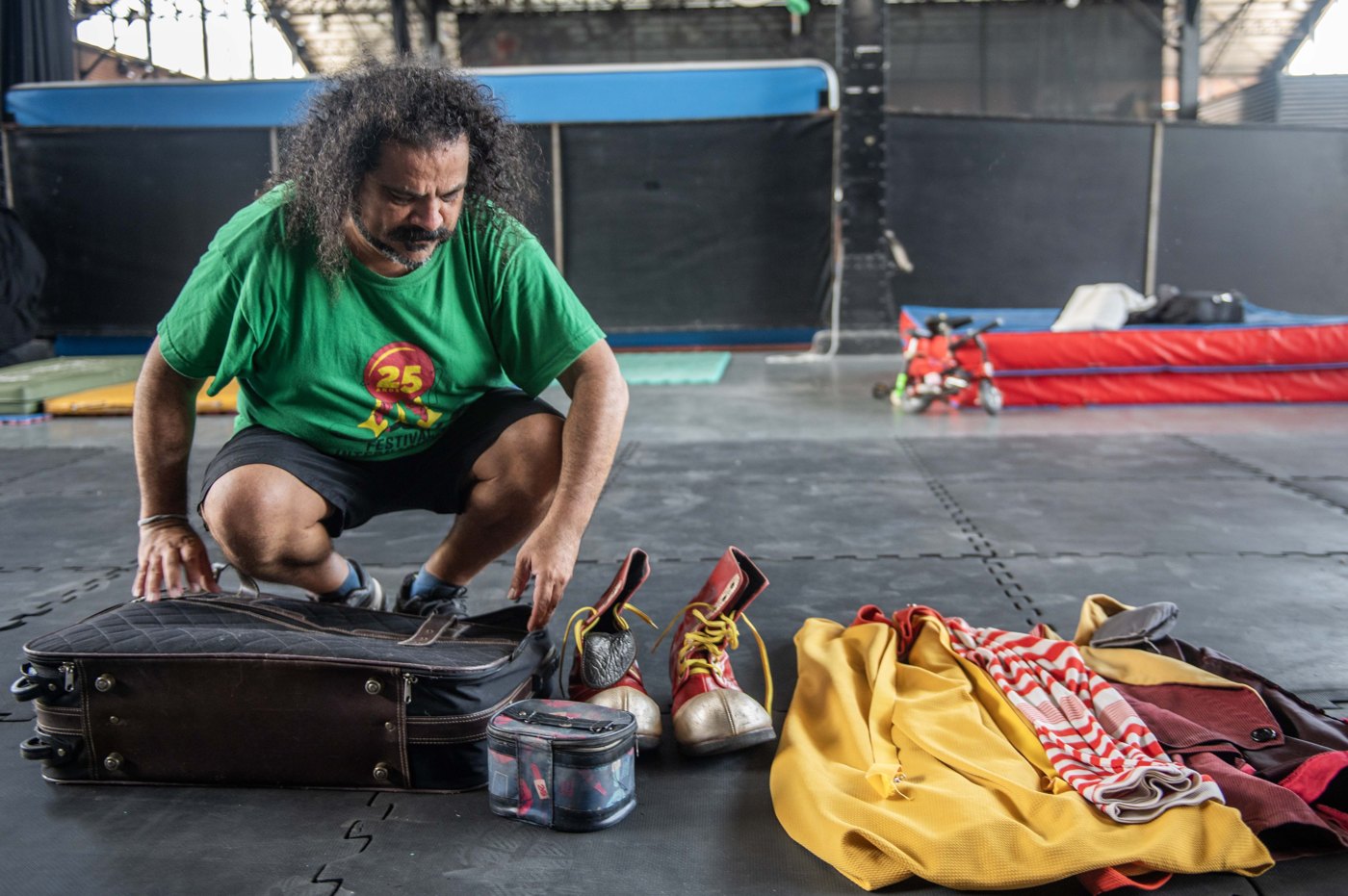 El payaso Galupa prepara su valija con el vestuario de payaso, zapatos y ropa de colores