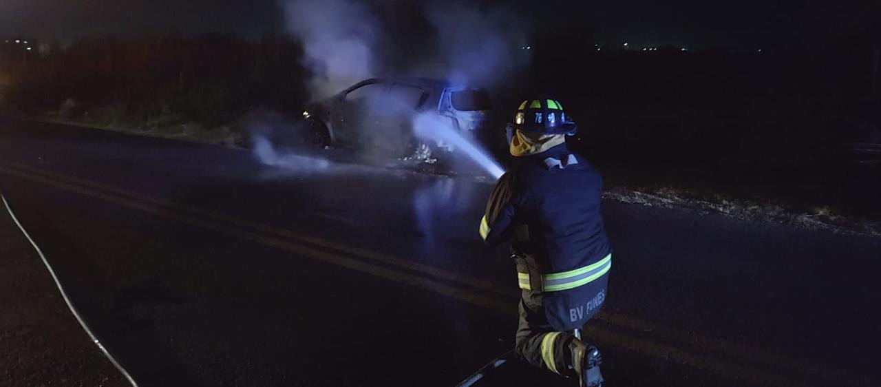 Bombero de Funes apunta la manguera contra el incendio de un auto en calle Mendoza