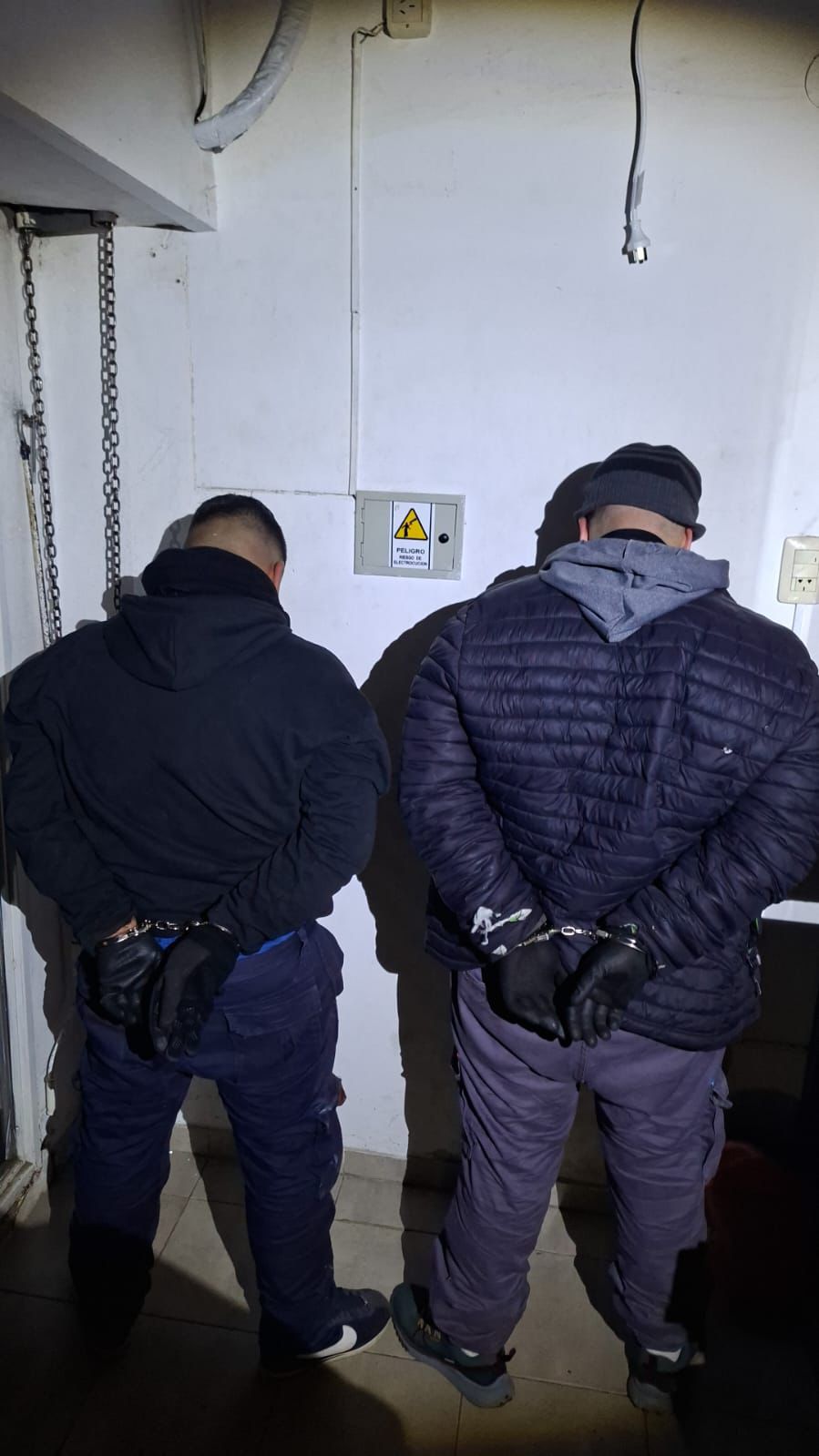 Robo Rapipago Rosario dos aprehendidos esposados de espaldas