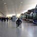 Una persona en silla de ruedas en una terminal de micros de larga distancia