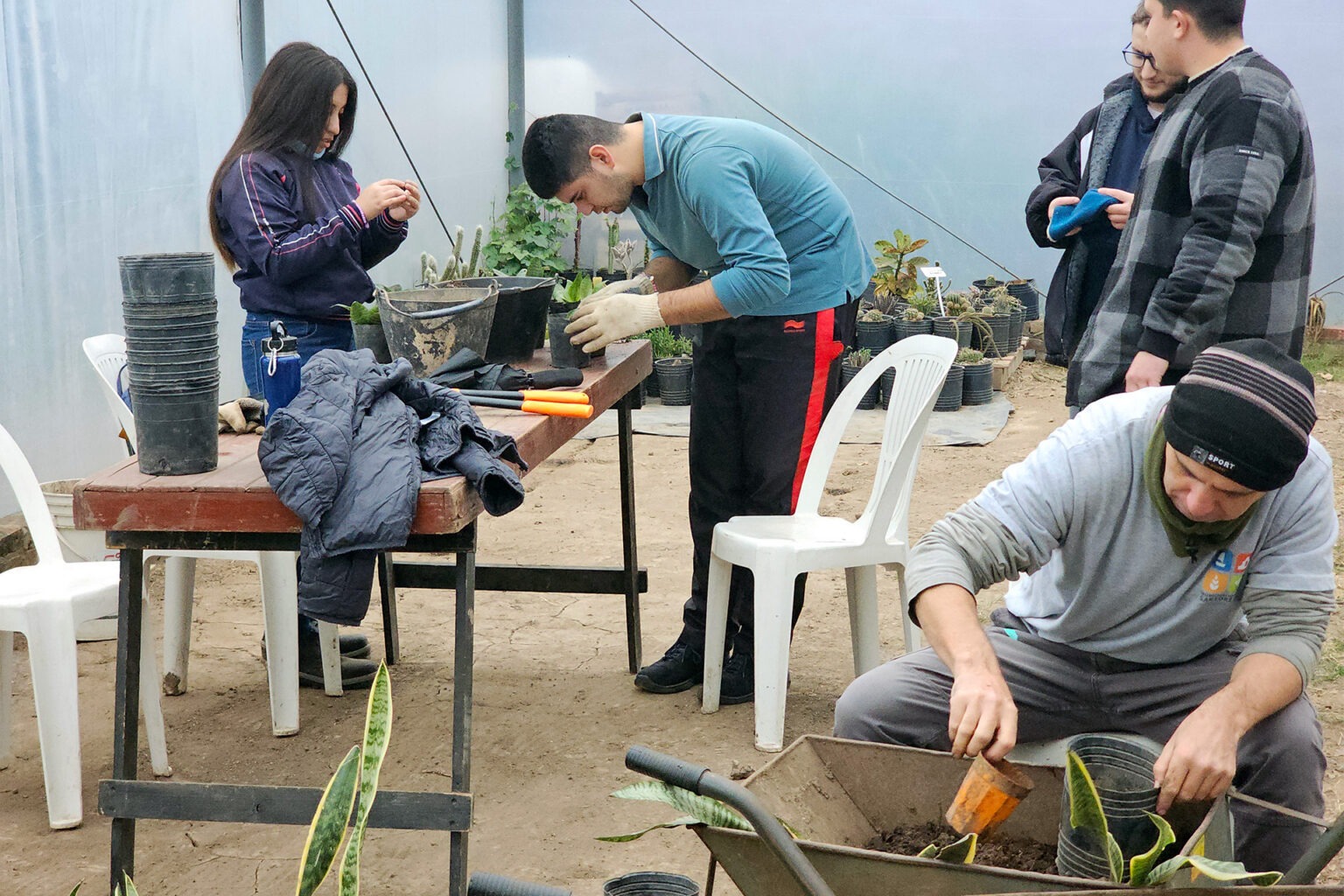 Vivero Inclusivo San Lorenzo: jóvenes preparando plantines con tierra en el Hojitas Verdes