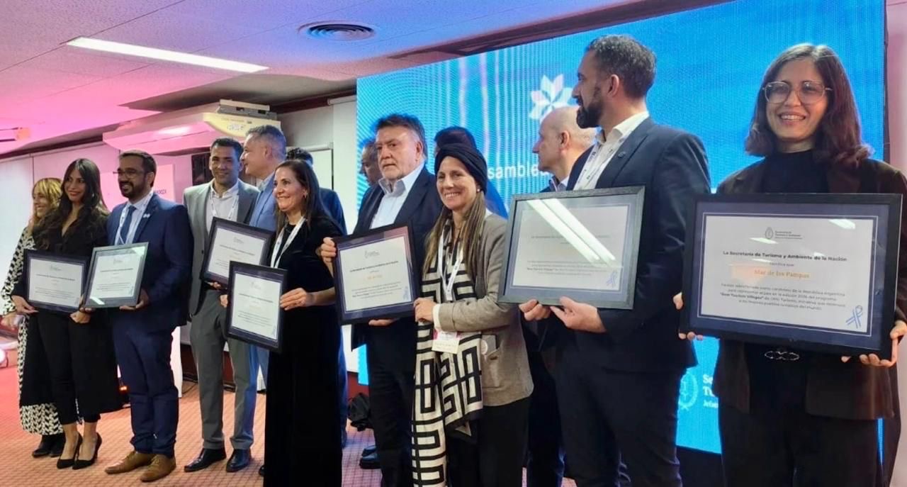 Marcela Aeberhard y autoridades reciben la placa de Best Tourism Villages en la Asamblea CFT Mendoza