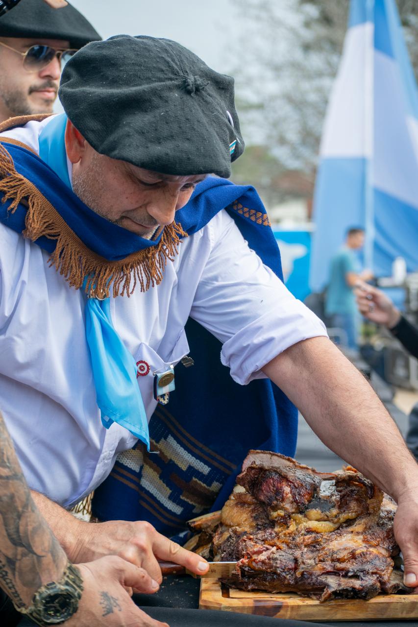 Asador con poncho y boina corta el Asado a la Estaca en Funes