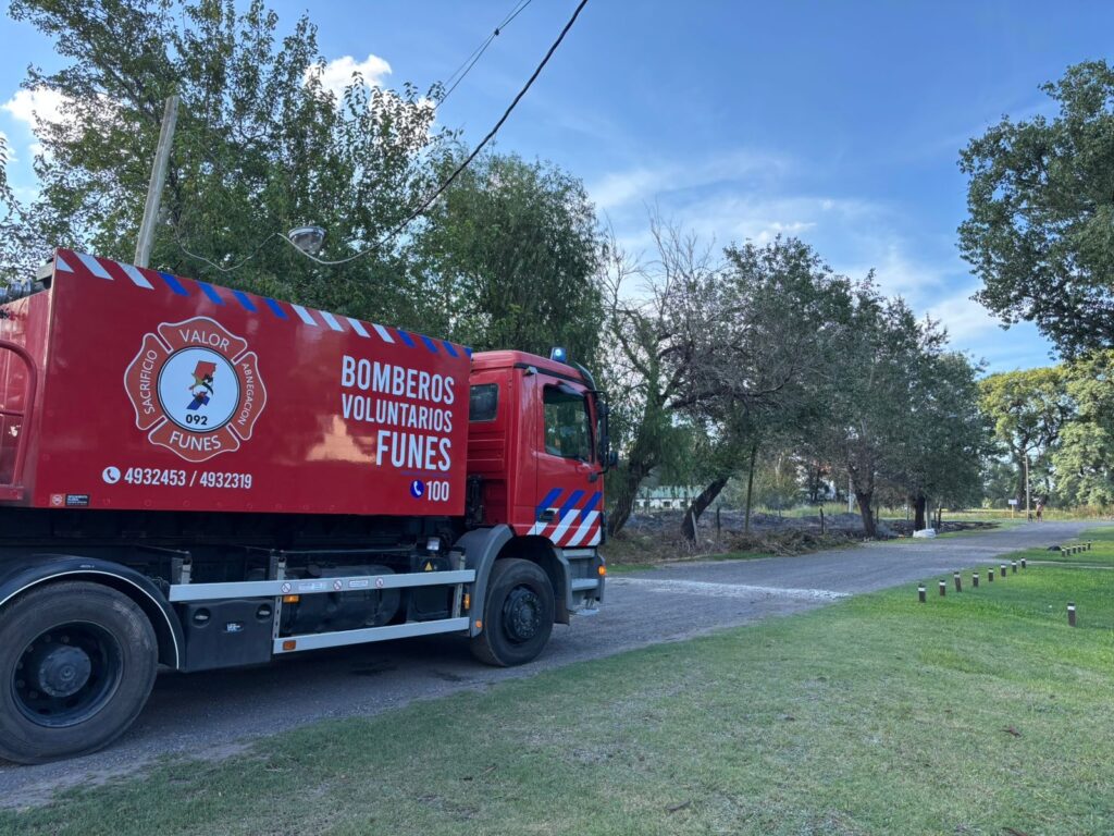 Bomberos Voluntarios de Funes junto a su autobomba en el cuartel