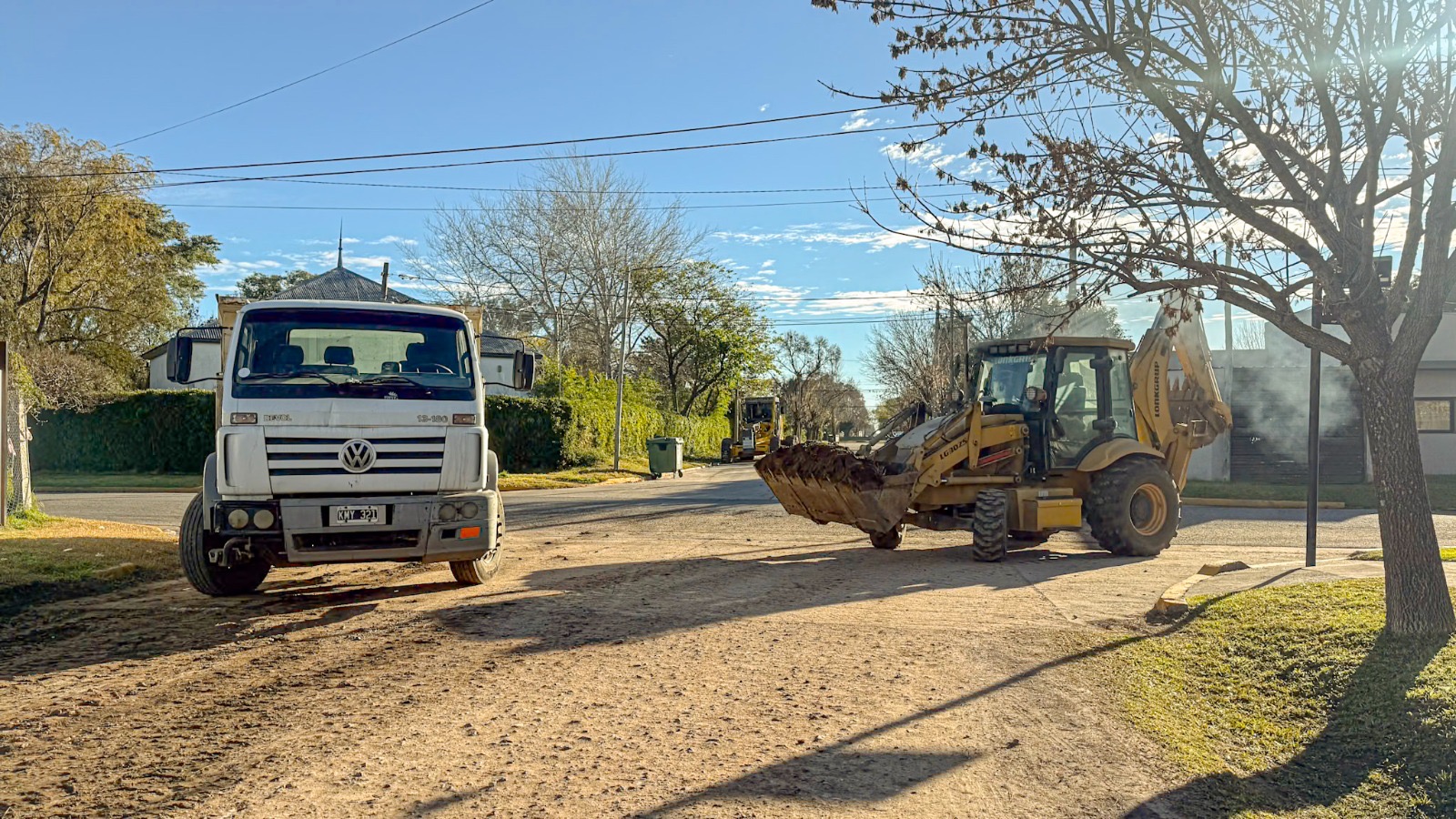 Camión y retroexcavadora en la pavimentación en Roldán