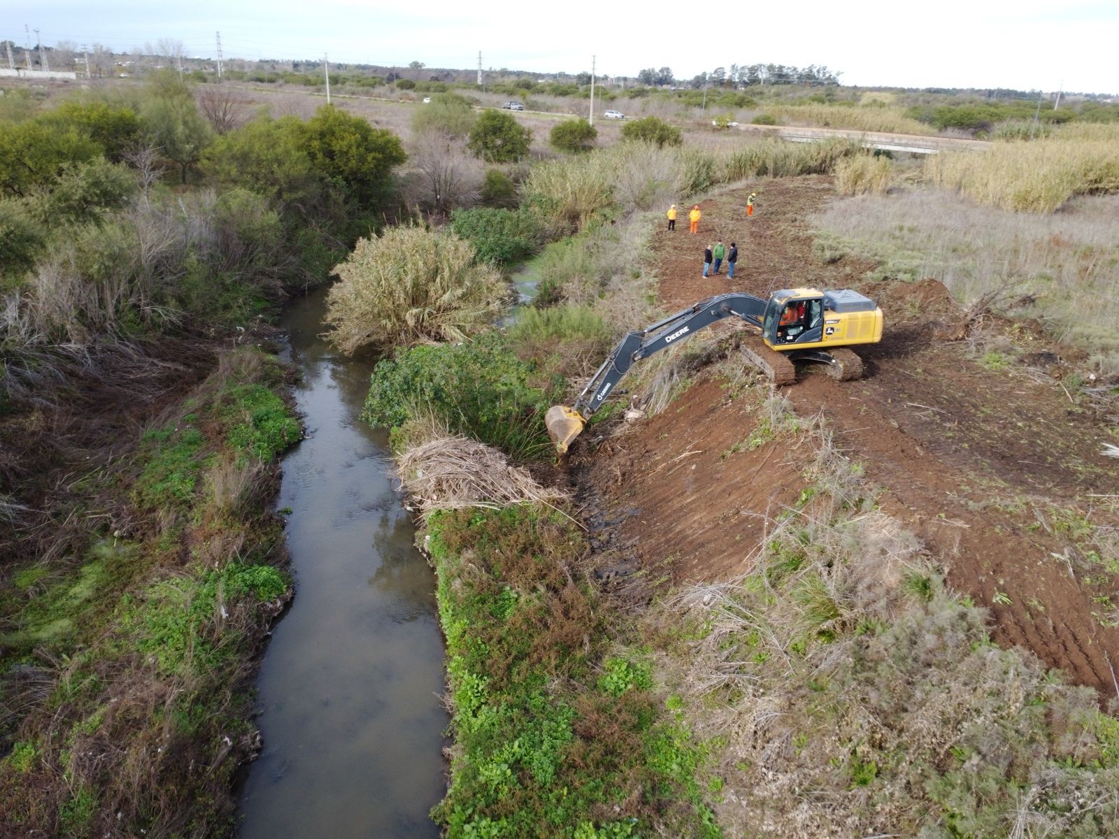 Excavadora trabajando en la limpieza de canales troncales en el arroyo Ludueña
