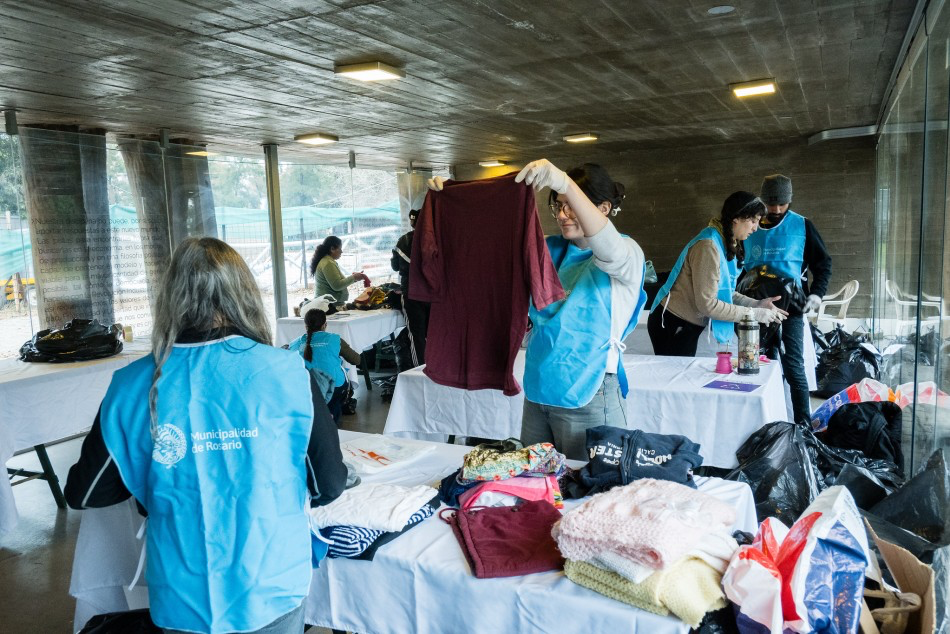 Voluntarias clasifican prendas durante la donación de ropa en Rosario