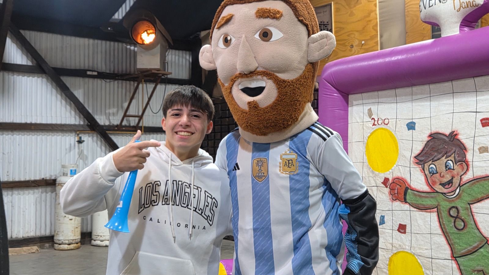 Un joven se saca una foto con la mascota de Messi en el Fan Fest de Roldán
