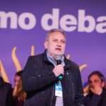 Marcelo Lewandowski habla con micrófono ante el banner de El Peronismo Debate en Concepción del Uruguay