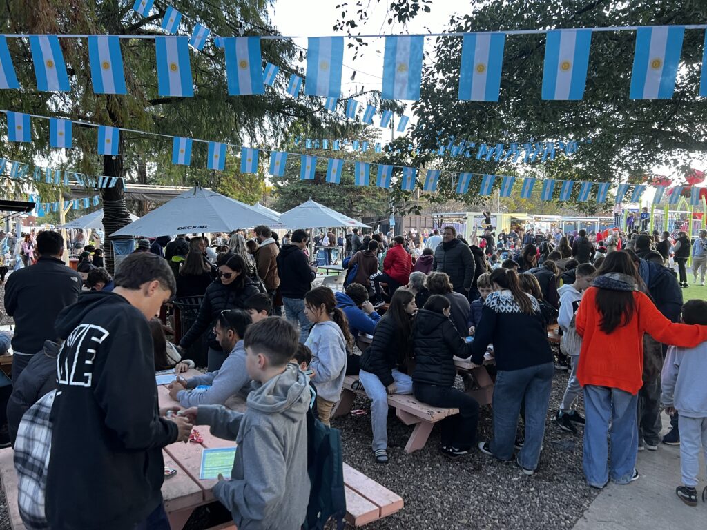 Familias en mesas llenas y predio colmado en el Mercado Don Bosco de Funes