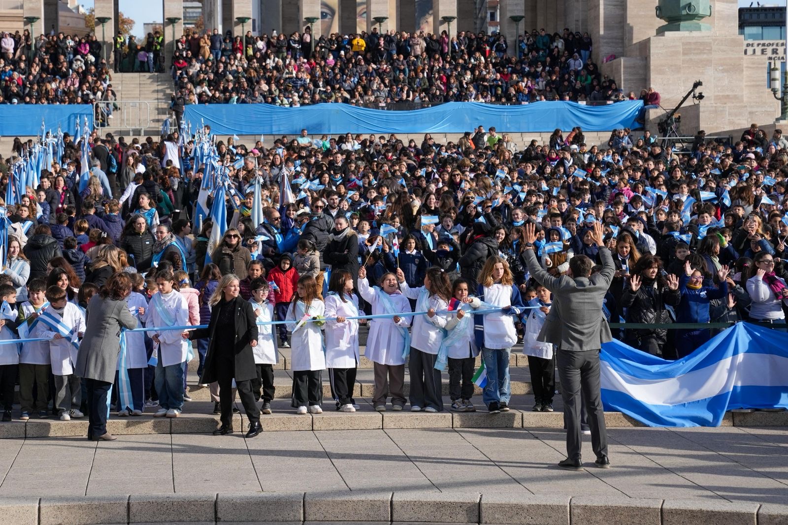 Multitud y alumnos con banderas argentinas en el Monumento a la Bandera restaurado