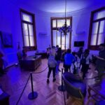 Visitantes recorren una sala del Museo Histórico de Santa Fe iluminada de azul