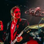 Patricio Pato Sardelli (Airbag) en escenario con el dron volando muy cerca antes del guitarrazo
