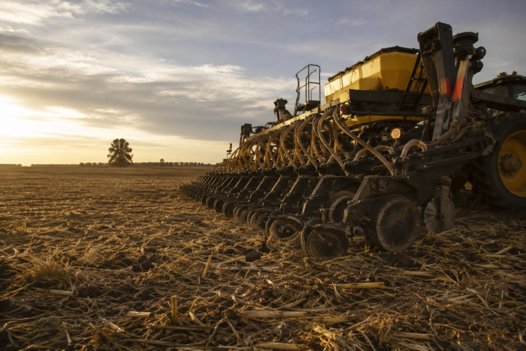 Sembradora trabajando en un campo de la región núcleo al atardecer durante la siembra de trigo