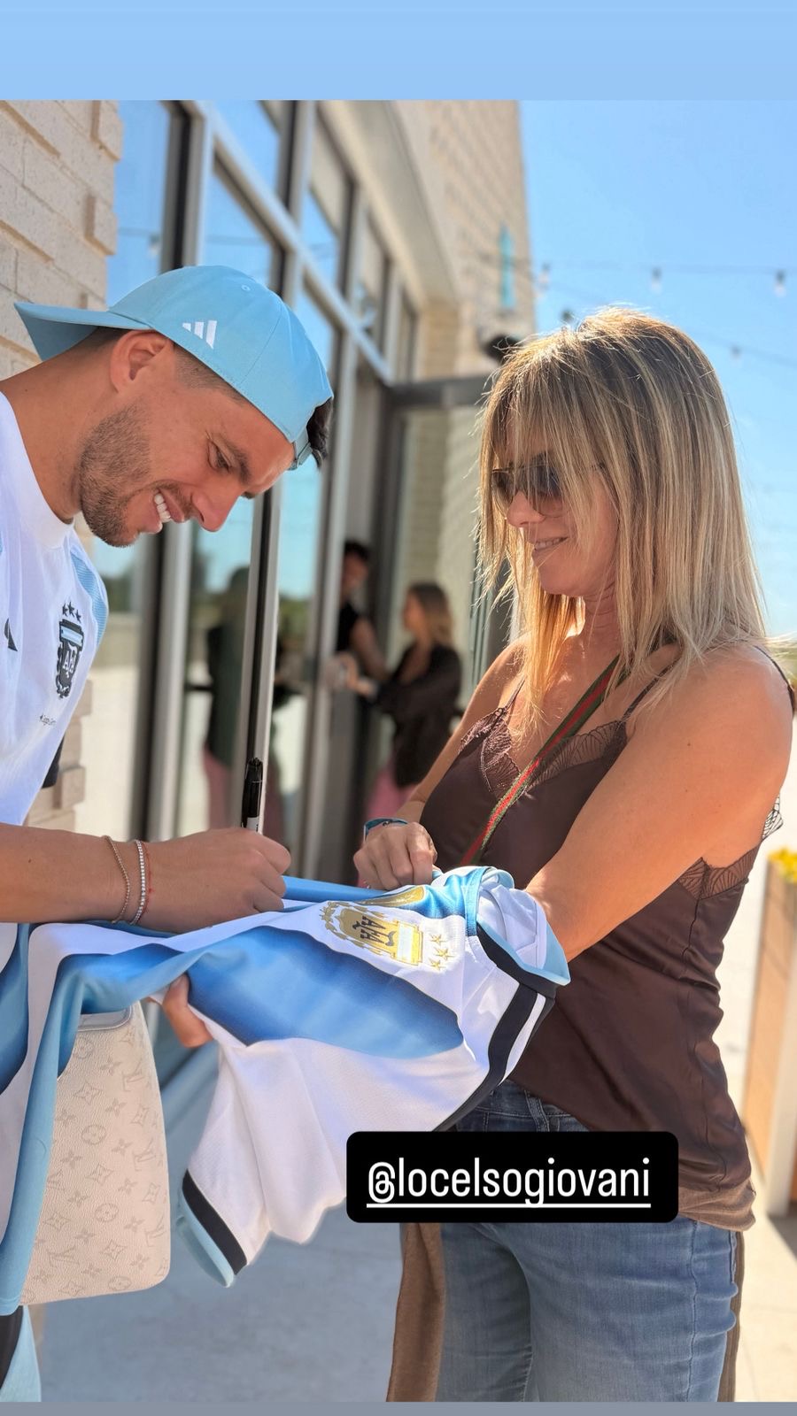 Vanina Bermúdez con Giovani Lo Celso firmándole la camiseta de Argentina en Kansas City