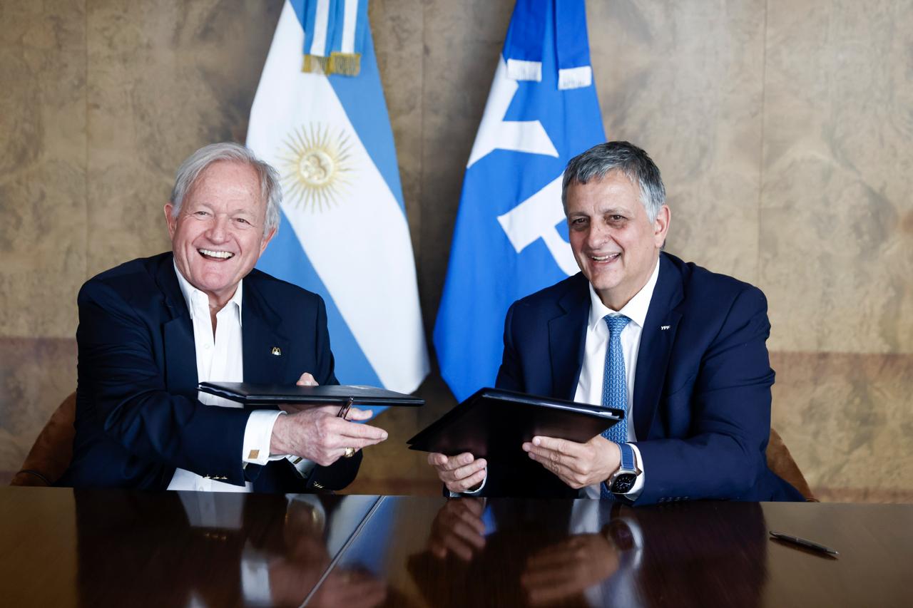 Horacio Mar&iacute;n (YPF) y Woods Staton (Arcos Dorados) firman el acuerdo entre YPF y McDonald's junto a las banderas