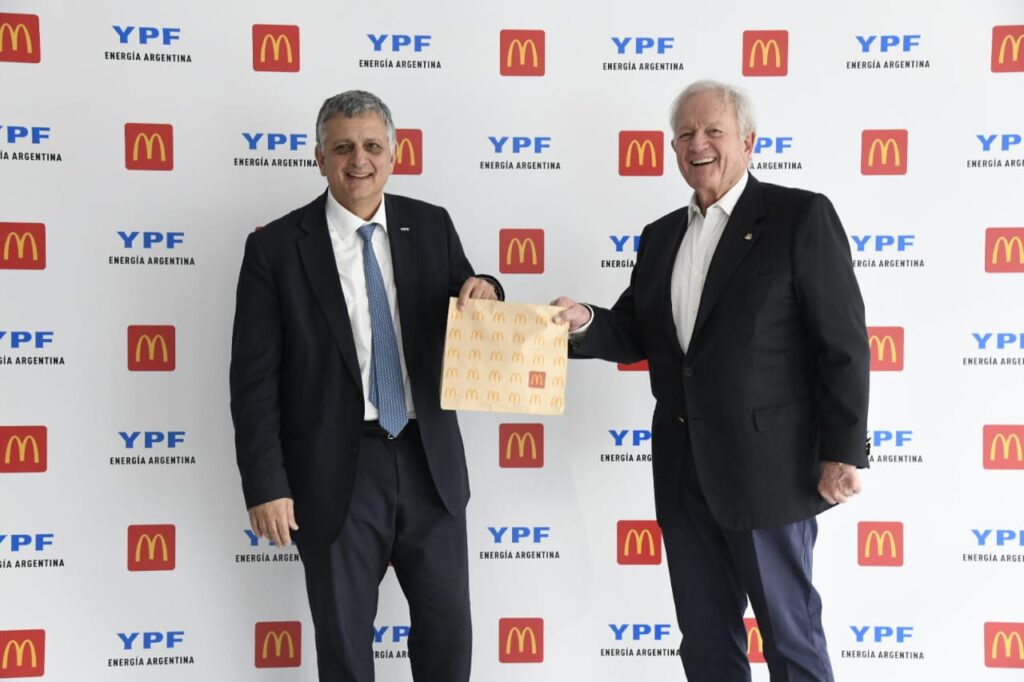 YPF y McDonald's: Horacio Marin y Woods Staton con una bolsa de McDonald's ante el backdrop del acuerdo
