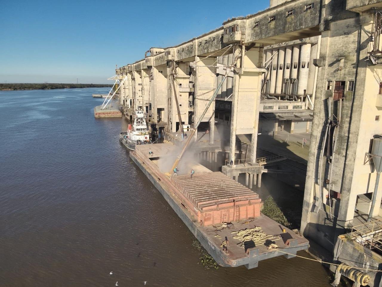 Terminal de granos sobre el río Paraná con barcazas en carga