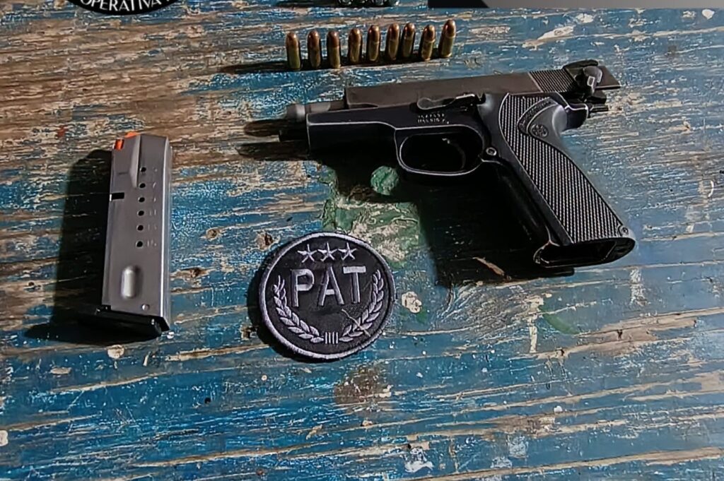 Una pistola calibre 9 milímetros, su cargador y municiones secuestradas por la Policía sobre una mesa de madera