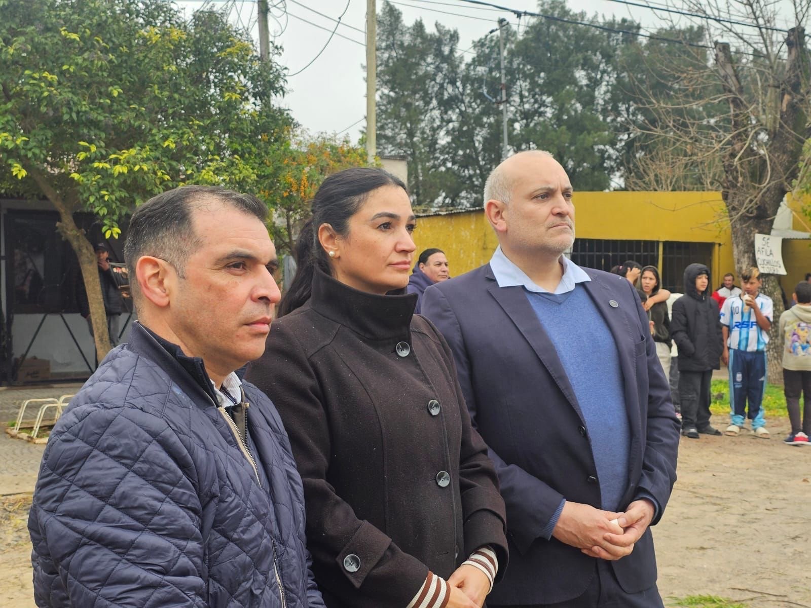 Funcionarios provinciales y judiciales observan el operativo de demolición, con vecinos detrás