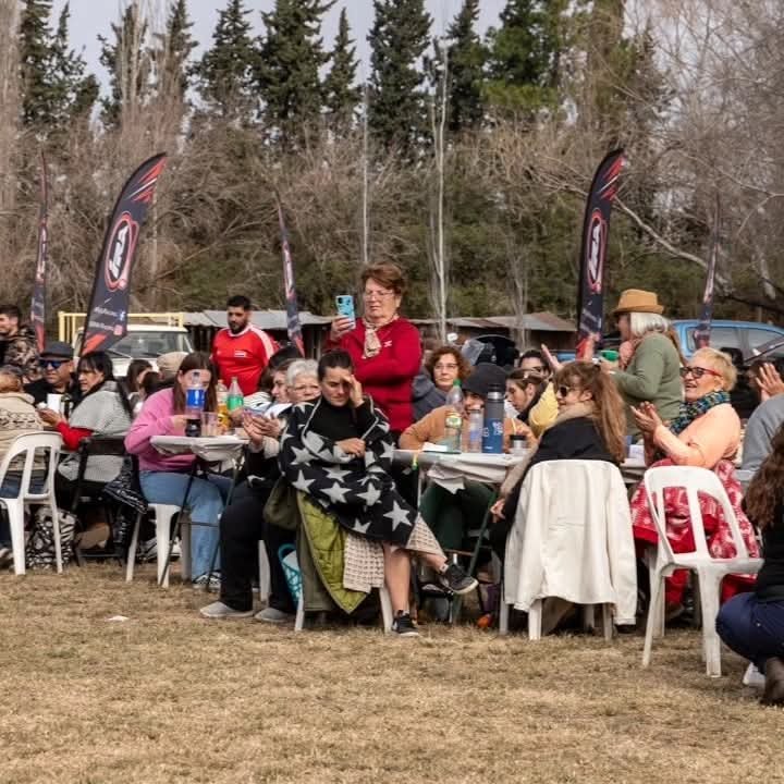 Familias sentadas en mesas y sillas al aire libre durante la Fiesta del Arroz Soldinense
