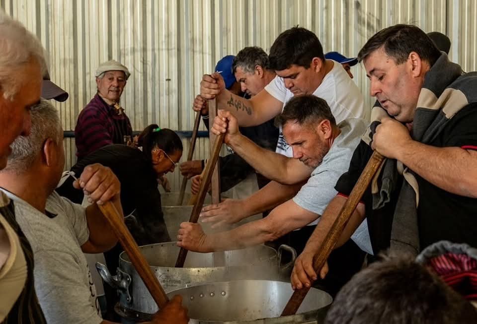 Un grupo de cocineros revuelve con palas de madera las ollas de arroz durante la Fiesta del Arroz de Soldini