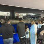 Messi en Funes: aterrizó en Rosario pasadas las 6 y los hinchas lo esperaban desde la una de la madrugada Una familia con la bandera argentina y camisetas de la Selección mira la pista desde el ventanal del aeropuerto