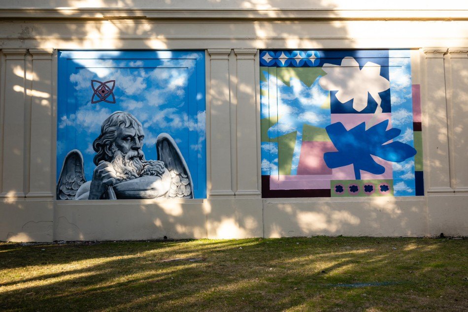 Mural colectivo en el cementerio El Salvador de Rosario: figura de un ángel sobre un cielo pintado