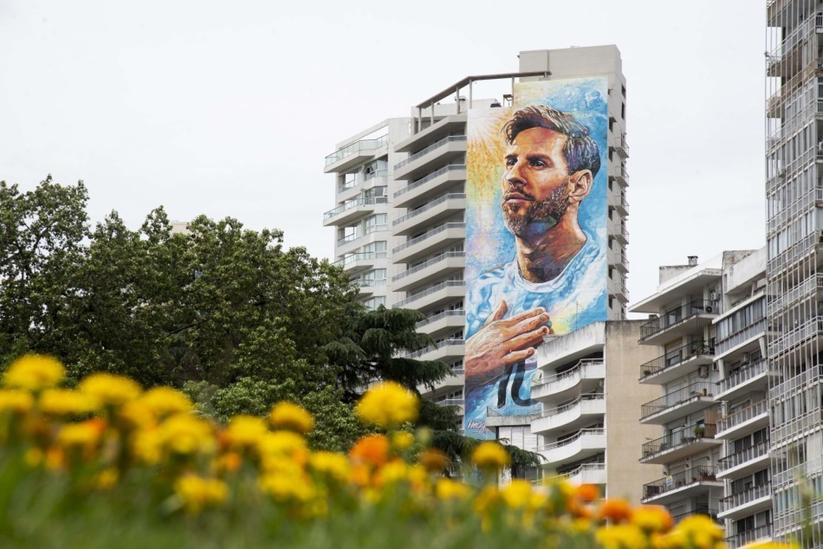 Mural de Messi en Rosario con la camiseta de la Seleccion y flores en primer plano