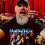 Murió Pato Strunz, histórico baterista de Hermética y fundador de Malón Pato Strunz con los brazos en alto y palillos en la mano, frente a su batería, con una remera de Hermética