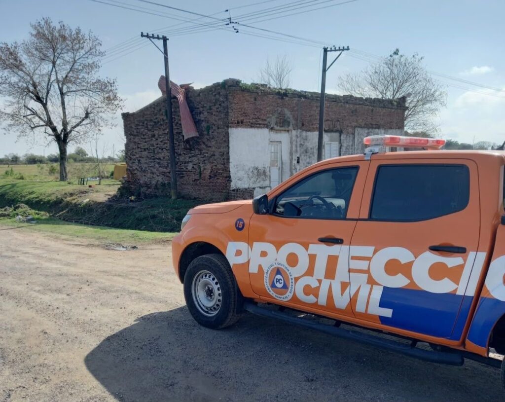 Una camioneta de Protección Civil de Santa Fe frente a una vivienda con el techo volado por el temporal
