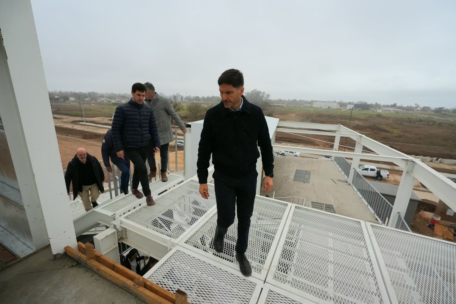El gobernador baja por una escalera metálica durante la recorrida por el polo deportivo de Rafaela