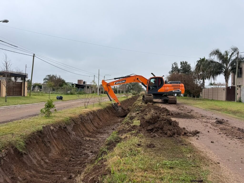 Una retroexcavadora limpia un canal en un barrio de Roldán, dentro del plan preventivo ante El Niño