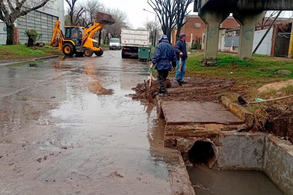 Personal municipal y maquinaria trabajan en la limpieza de desagües y bocas de tormenta en un barrio de San Lorenzo