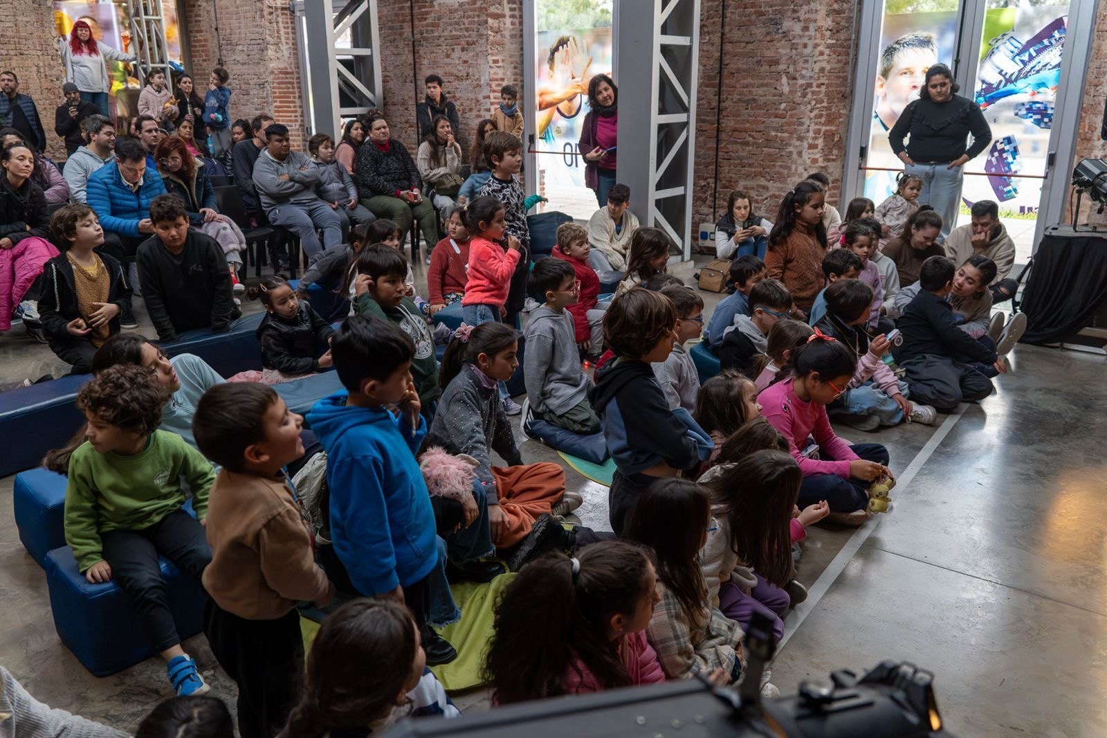 Familias y chicos sentados disfrutan de una función cultural durante las Vacaciones Copadas