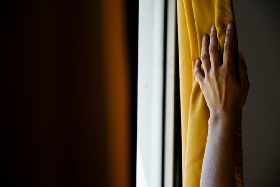 Una mano abre la cortina hacia la luz